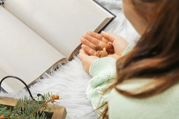 Woman holding nuts near book
