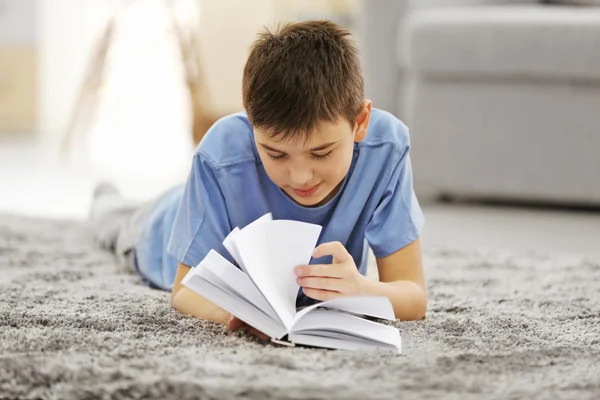 Boy reading books on a floor