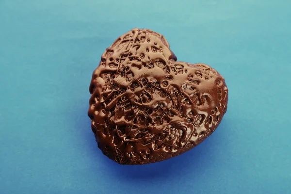 Chocolate heart on a blue background, close up