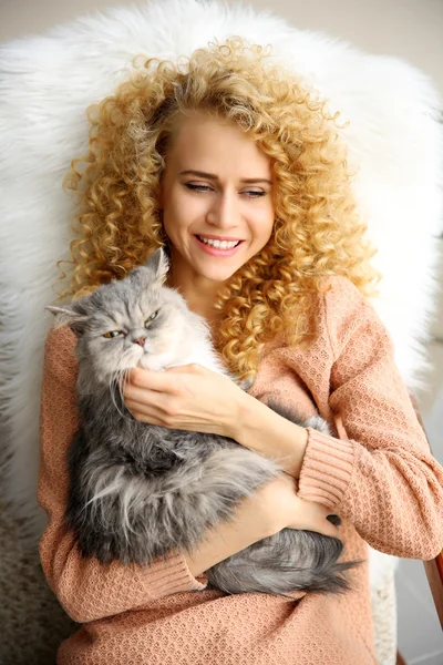 Young woman and cat lying on bed