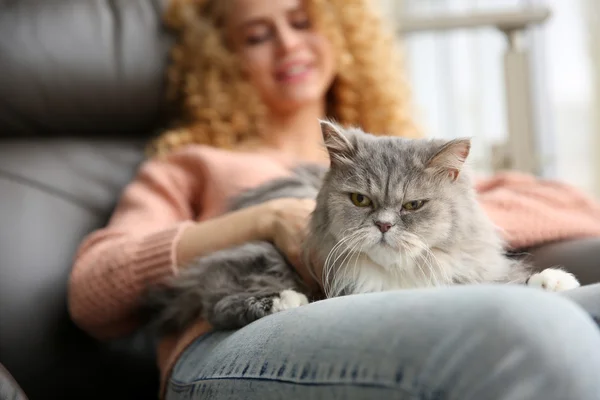 Young woman and cat beside window