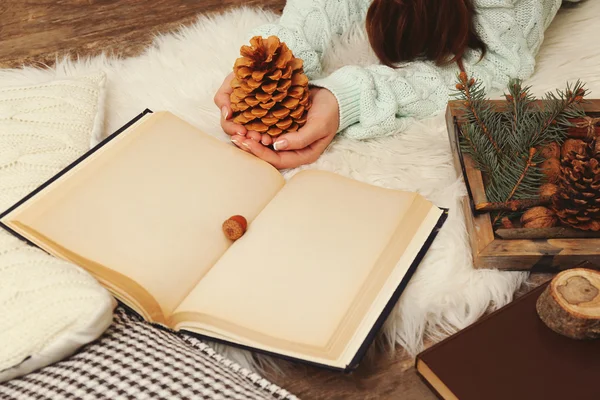 Woman holding nuts near book