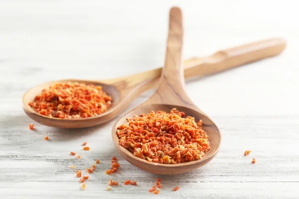 Two wooden spoons with spice on the table, close-up