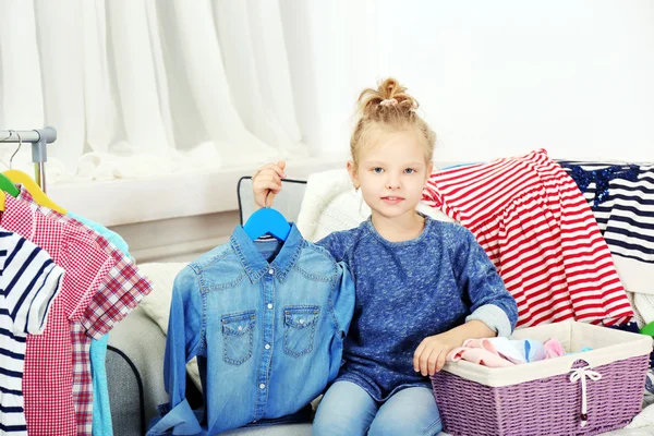 Little girl trying on clothes