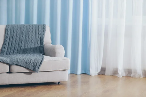 Sofa in room with curtains