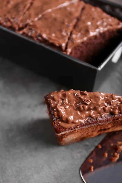 Delicious chocolate cake with nut cream on grey background, close up