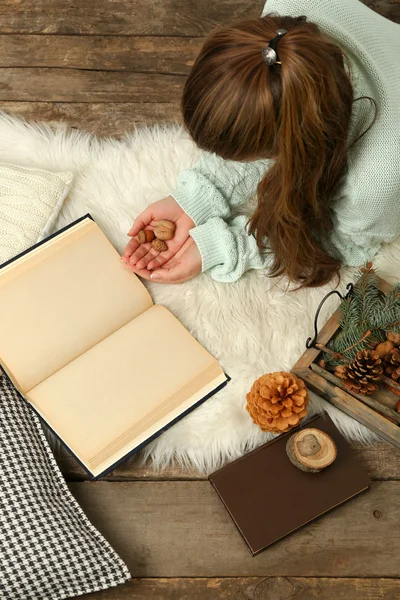 Woman holding nuts near book