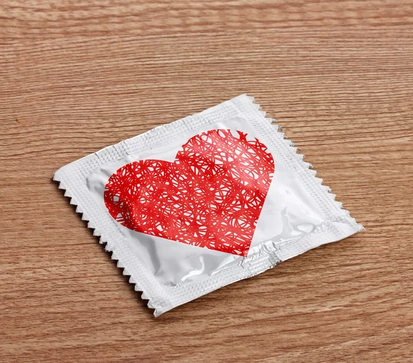 Condom with heart on table