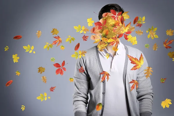 man and falling autumn leaves