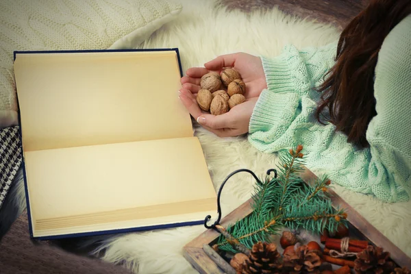 Woman holding nuts near book