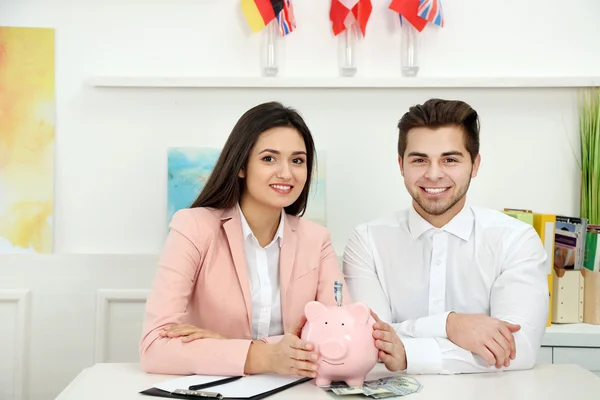 Couple holding in hands piggy bank
