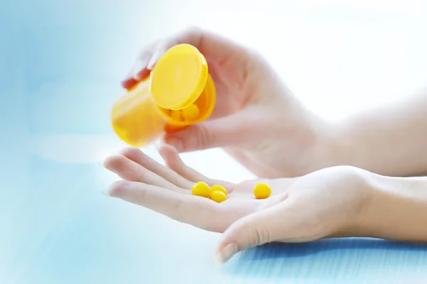 Woman spills yellow medical capsules