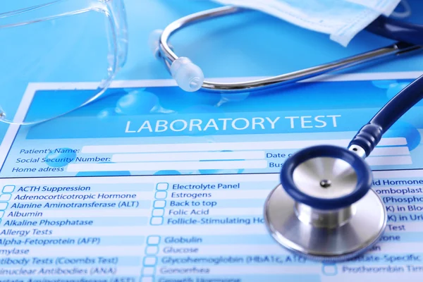 Laboratory test list, stethoscope and eyeglasses