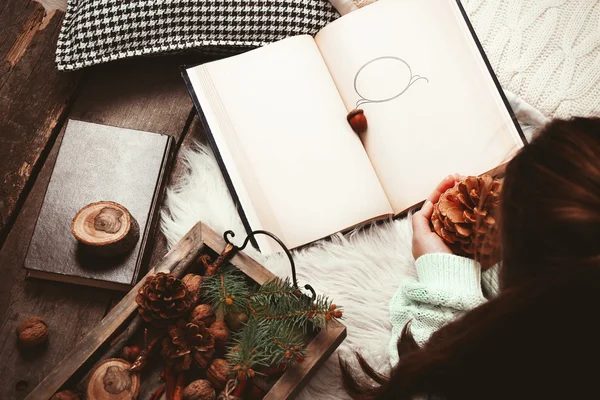 Woman holding nuts near book