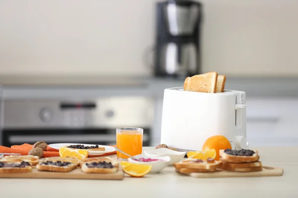 Toaster with dishes, sandwiches and oranges
