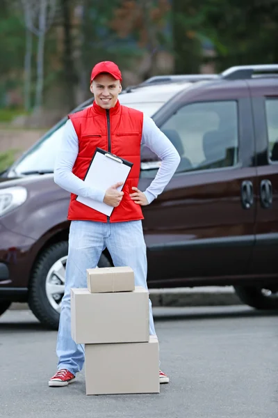 Delivery man with box and clipboard