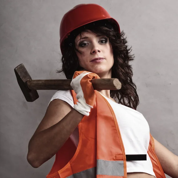 Sexy girl in safety helmet holding hammer tool