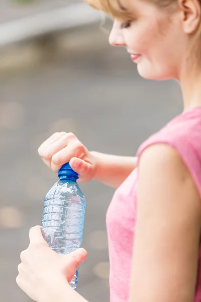 Woman with bottle of water taking break. Fitness.