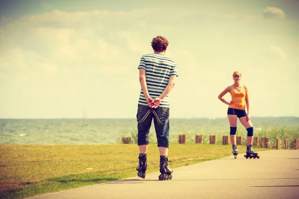 Young couple rollerblading in park