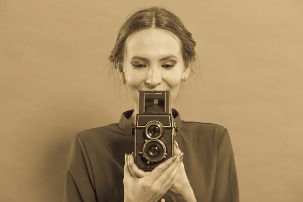 Woman taking picture with old camera