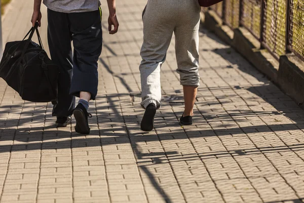 Couple man and woman walking with sport bags.