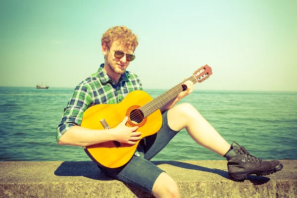 Young man guy playing guitar.