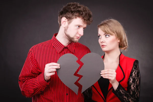 Sad couple holds broken heart.