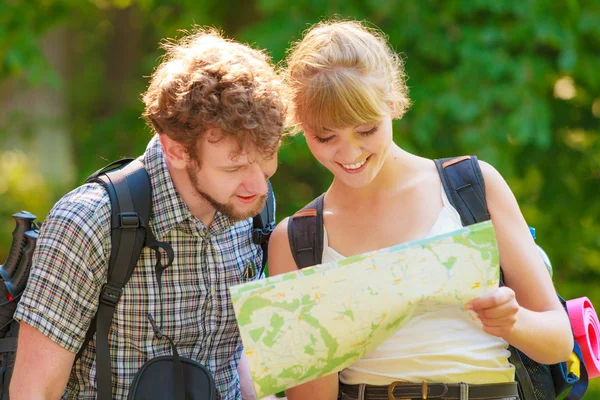 Hiking backpacking couple reading map on trip.