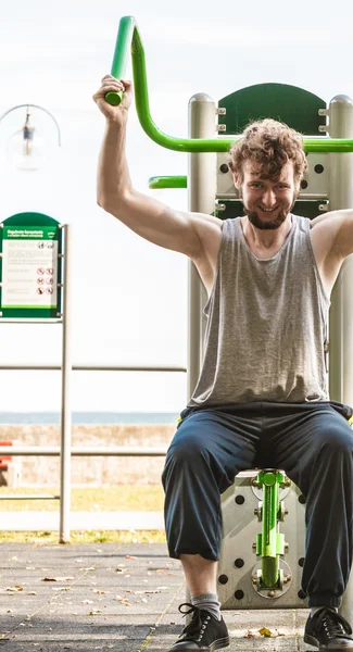 Active man exercising at outdoor gym.