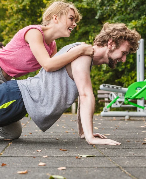 Man and woman doing push ups outdoor