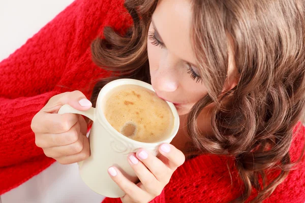 Girl red sweater holds mug with coffee