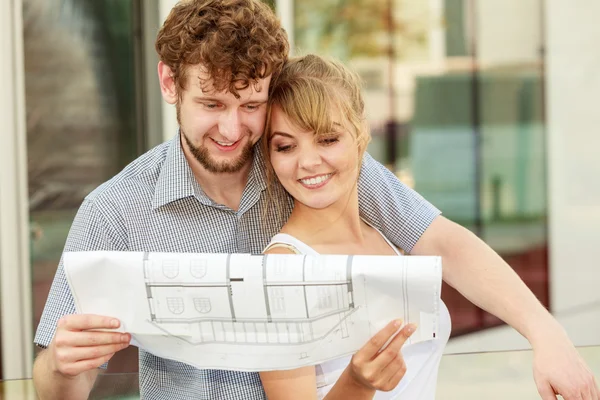 Couple with blueprint project  building plans outdoor