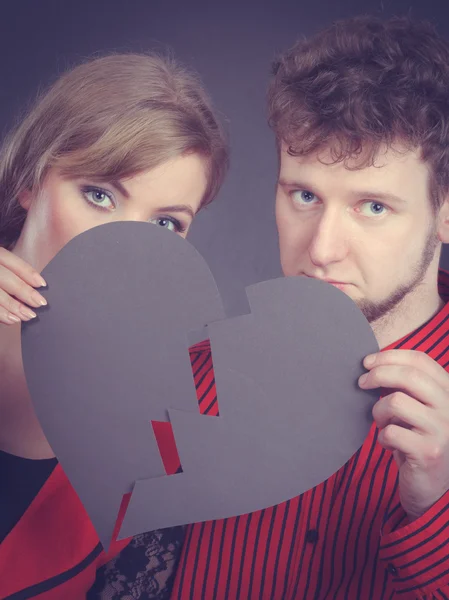 Sad couple holds broken heart.