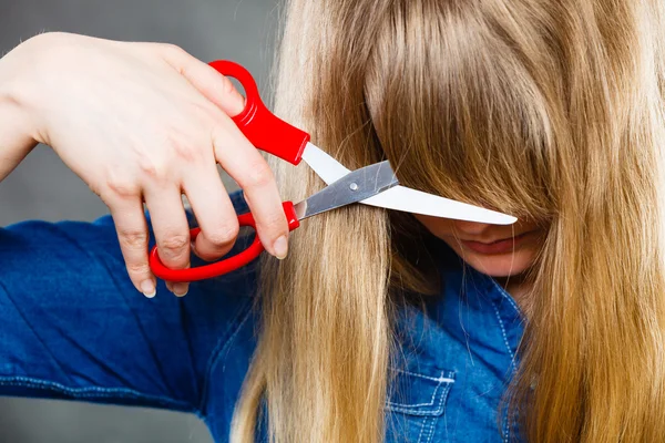 Woman cutting her fringe.