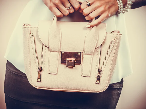 Fashionable girl holding bag handbag.