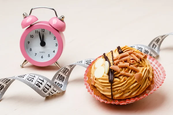 Sweet food measuring tape and clock on table