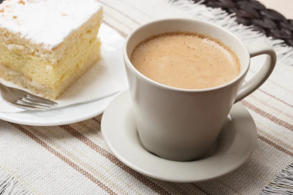 Cup with coffee and cake on table