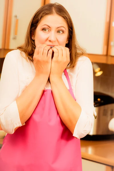 Unhappy housewife in kitchen