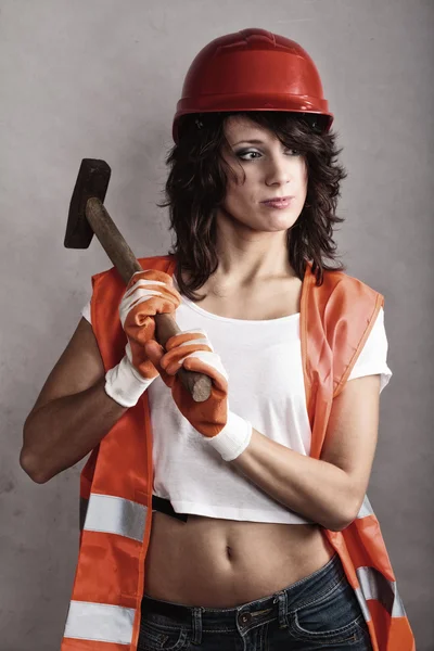 Sexy girl in safety helmet holding hammer tool