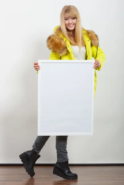 Woman in jacket with blank empty board banner.