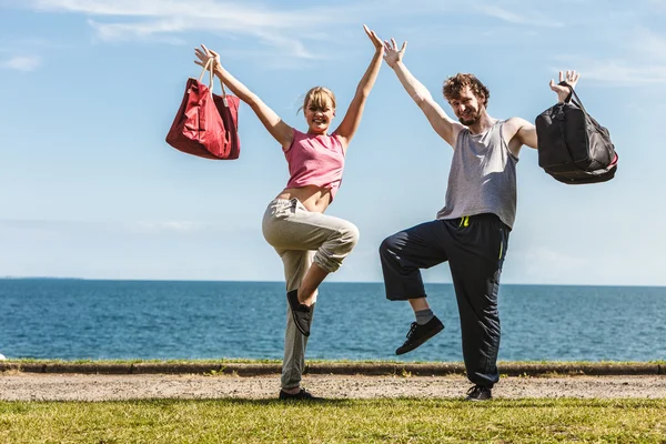 Happy couple man and woman with sport bags.