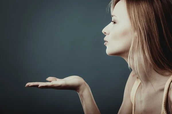 Young attractive woman sending hand kiss.