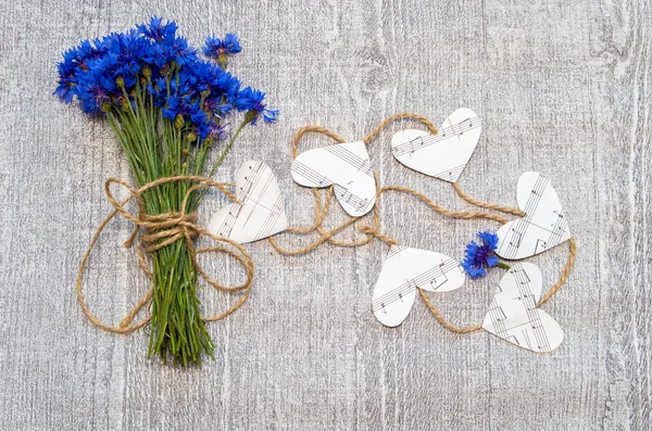 Bouquet of cornflowers with decorative hearts of music notes.