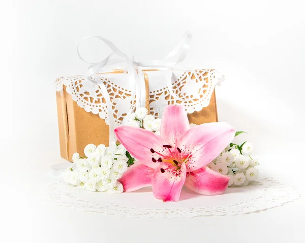 Fresh pink lily flower and gift box as a present for a holiday.
