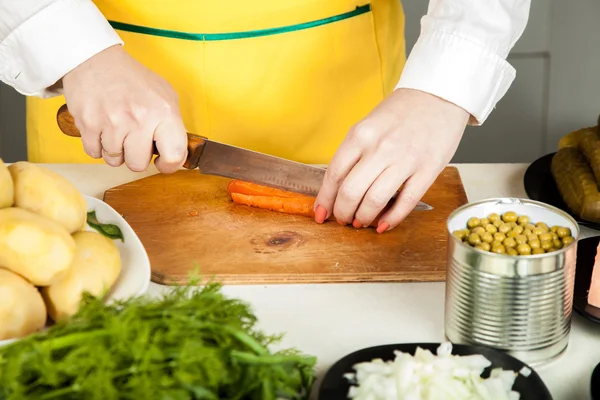 Woman cuts a knife carrot