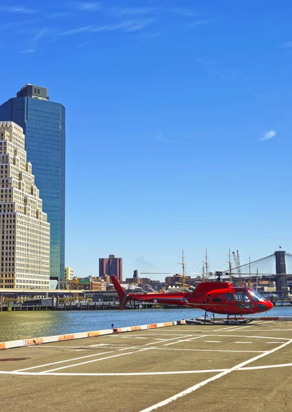 Red Helicopter landing on helipad in Lower Manhattan New York