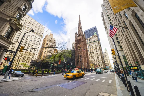 Trinity Church in Manhattan and street with tourists and traffic