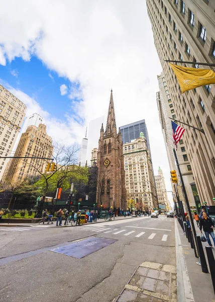 Trinity Church in Manhattan and street with traffic and tourists