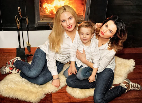 Beautiful family sitting on fur carpet at fireplace