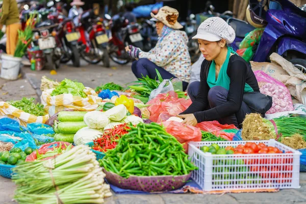 Asian trader selling mixed fresh vegetables in the street market
